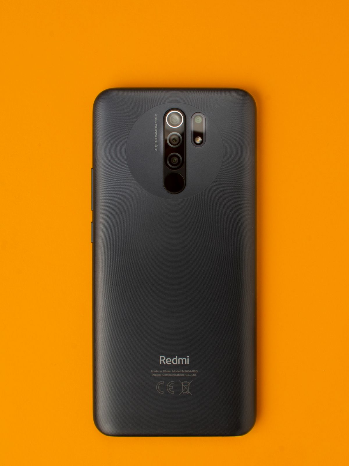 Dark smartphone on a vivid orange background