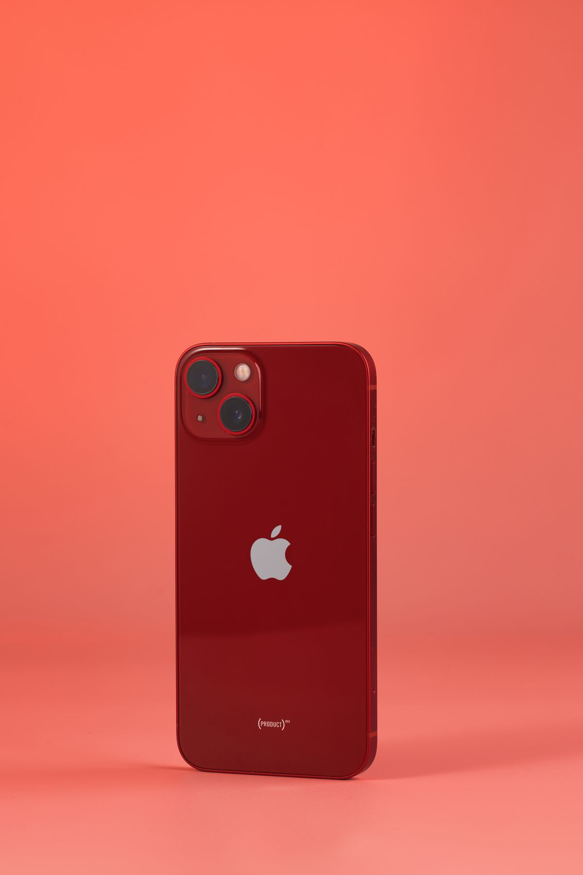 Red smartphone in a coral studio setting